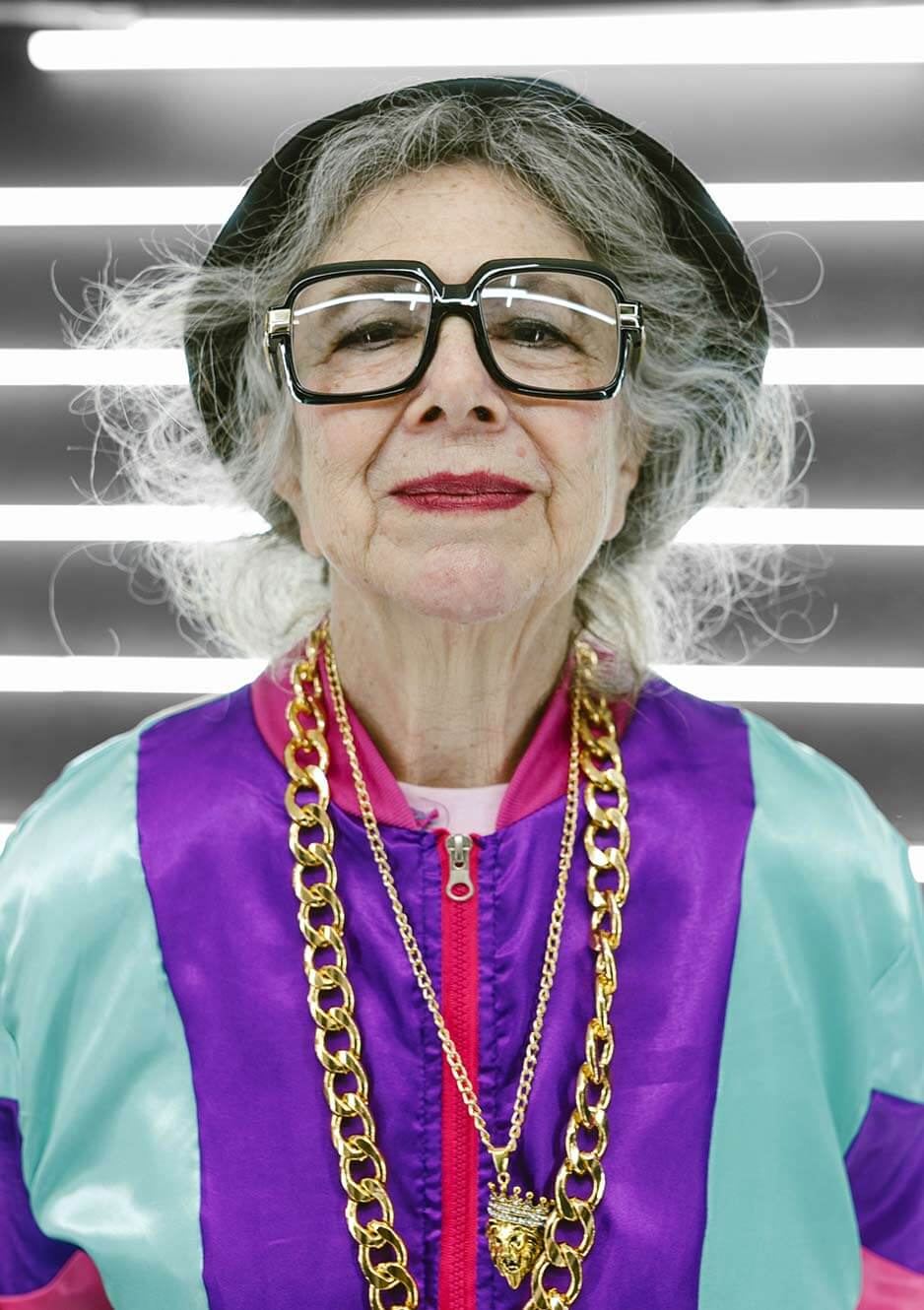 Oma, die gute Seele der StreamingBox, frontal mit großer Brille und Goldketten