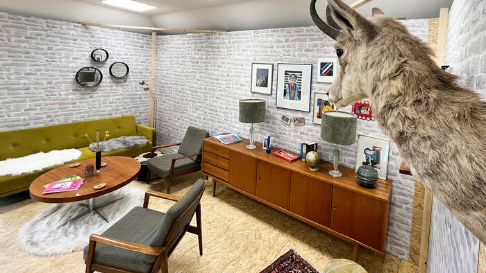 Sitzecke mit Sesseln, Couchtisch und Bilderwand